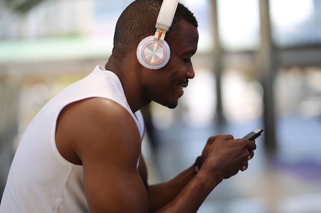 Uomo sorridente che usa il telefono mentre indossa le cuffie
