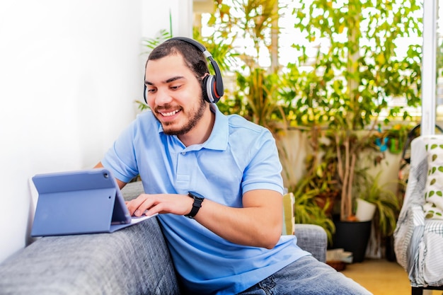 Uomo sorridente che usa la tavoletta digitale digitando il testo nel soggiorno