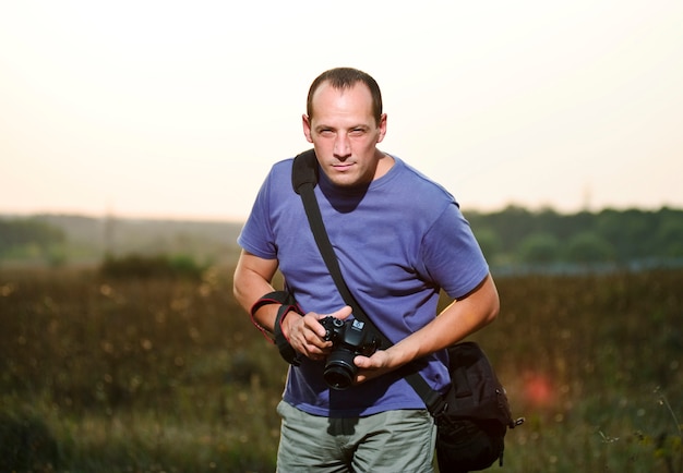 Uomo sorridente che usando i suoi oudoors della macchina fotografica.