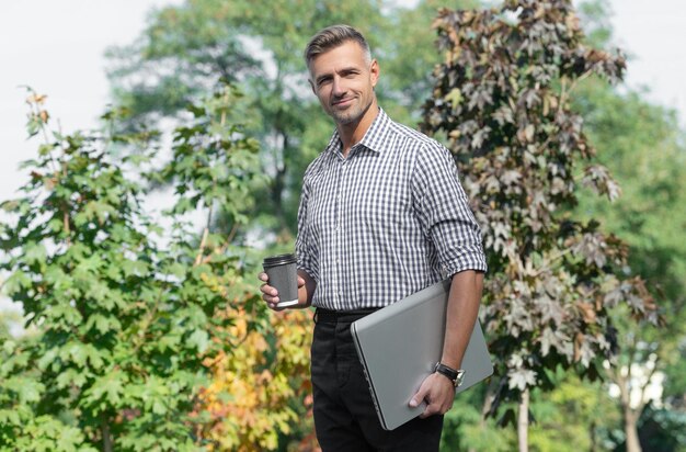 uomo sorridente con caffè uomo freelance beve caffè uomo d'affari all'aperto ha una pausa caffè