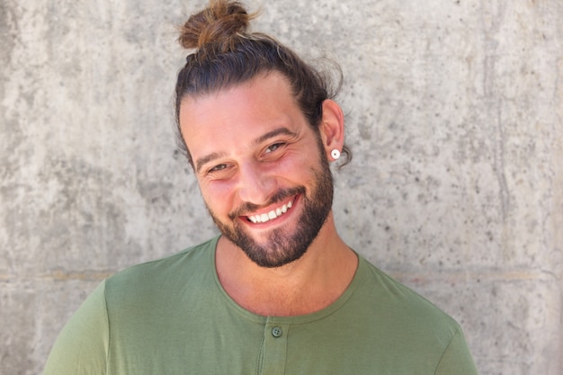 Uomo sorridente con coda di cavallo e barba