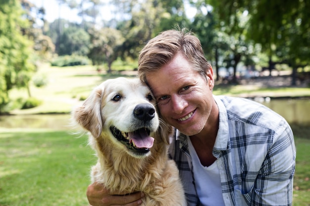 Uomo sorridente con il suo cane nel parco