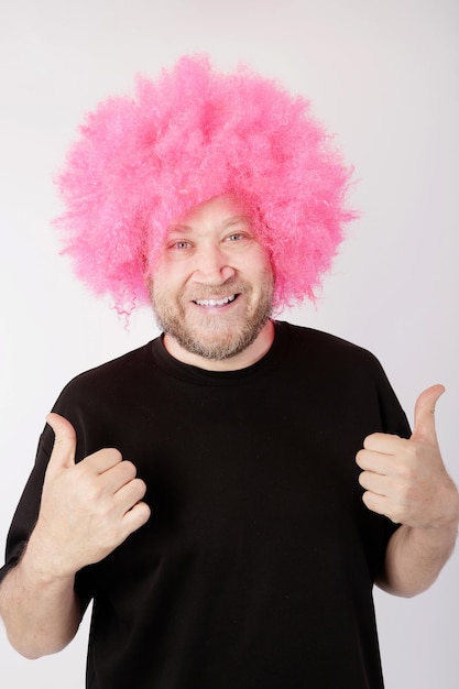 Uomo sorridente con parrucca afro rosa