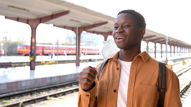 Uomo sorridente del colpo medio alla stazione ferroviaria