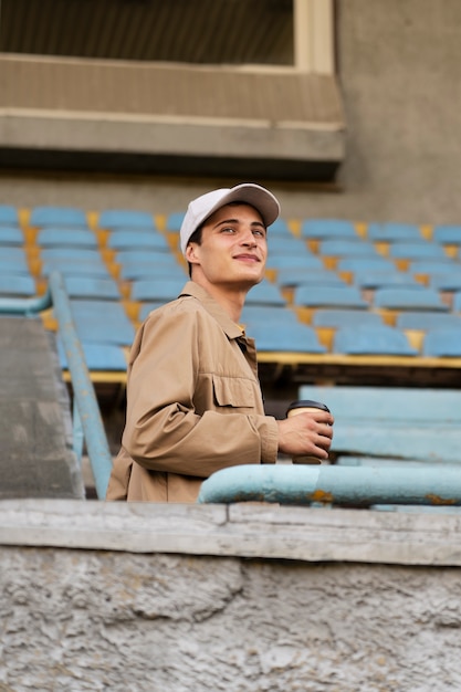 Uomo sorridente di vista laterale che tiene tazza di caffè