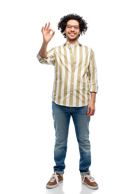 uomo sorridente felice con gli occhiali che mostra il gesto ok