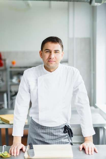 Uomo sorridente in uniforme da chef in cucina