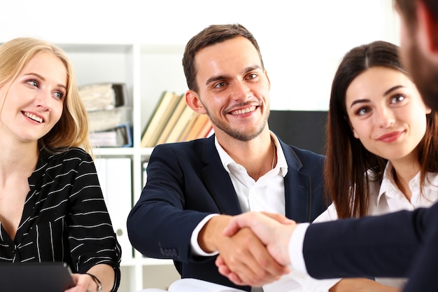 Uomo sorridente in vestito che agitano le mani come ciao nel ritratto dell'ufficio.