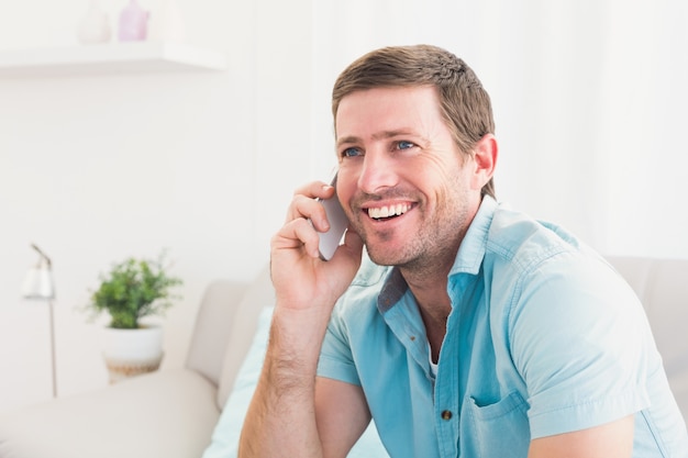 Uomo sorridente su un telefono