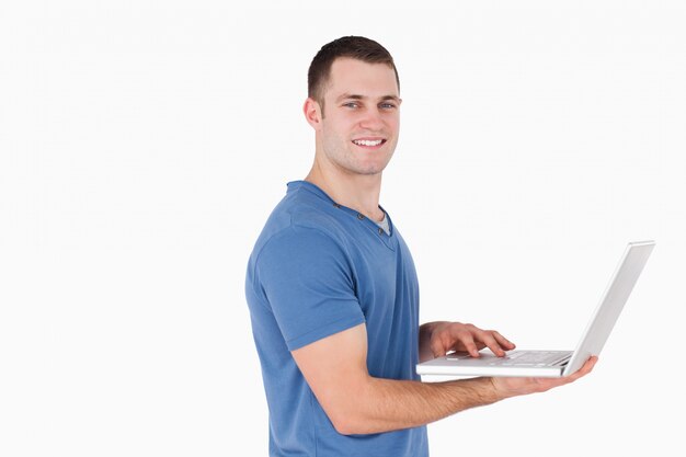 Uomo sorridente utilizzando un computer portatile