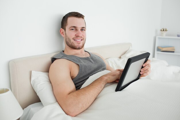 Uomo sorridente utilizzando un tablet PC