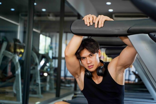 Uomo sportivo bello asiatico che agisce per una foto in palestra