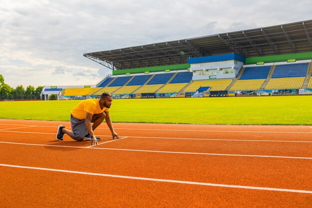 Uomo sportivo pensieroso che si concentra e si prepara per la corsa allenando l'atleta corridore afroamericano