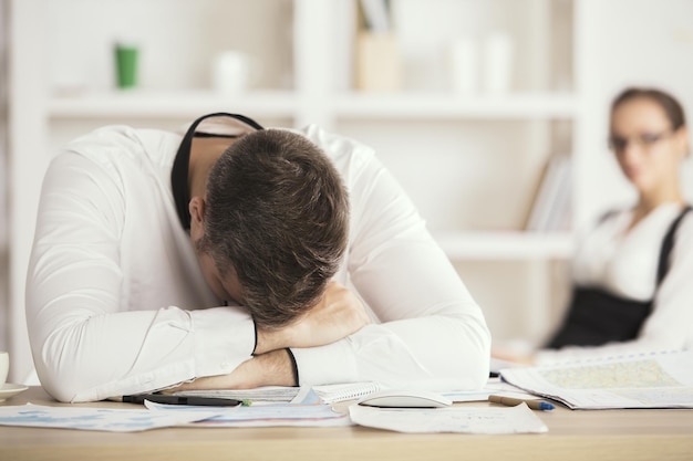 Uomo stanco che dorme nell&#39;ufficio