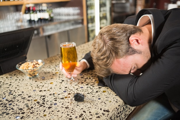 Uomo stanco che mangia una birra