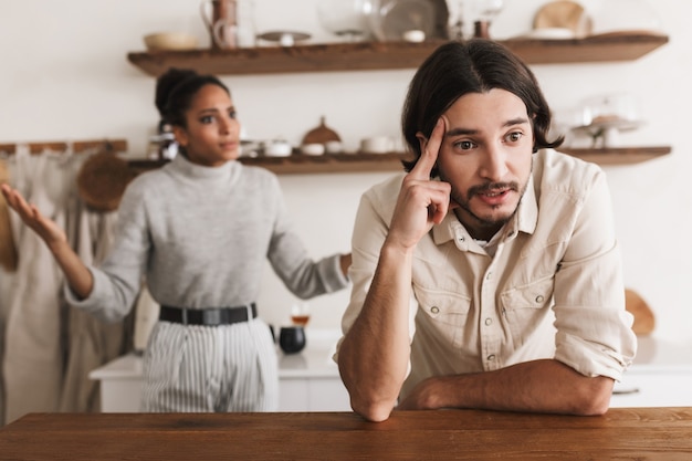 Uomo stanco con la barba che si appoggia sul tavolo mentre purtroppo