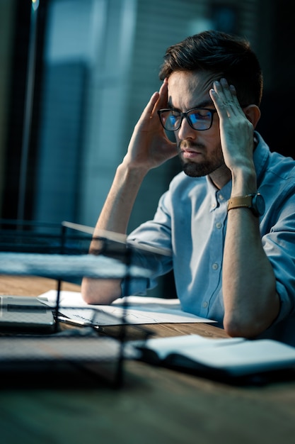 Uomo stanco con mal di testa in ufficio