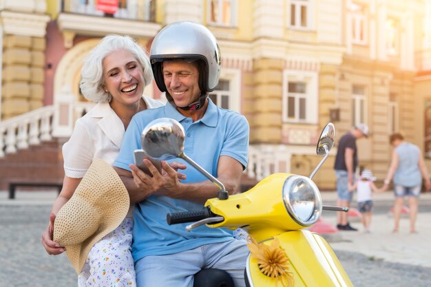 Uomo su scooter con telefono.