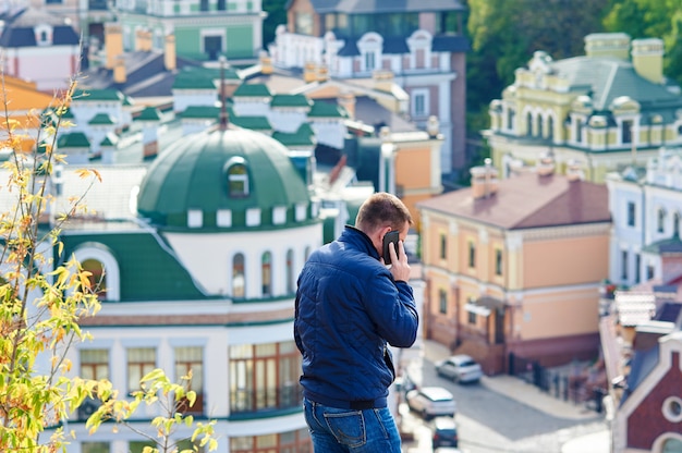 Uomo su sfondo città parlando al telefono