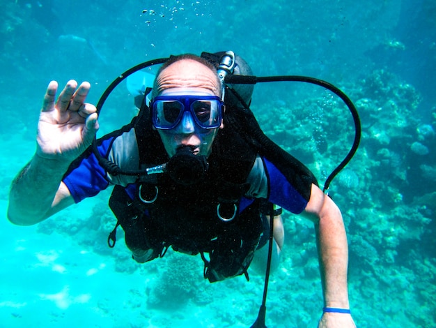 Uomo subacqueo e bellissima barriera corallina colorata sott'acqua.