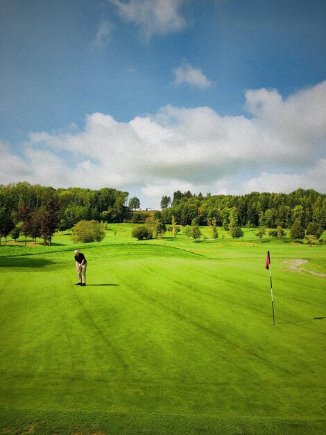 Uomo sul campo da golf contro il cielo