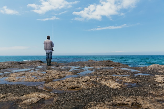 Uomo sulla pesca terrestre su un mare