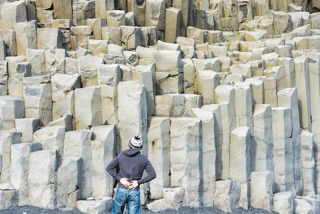Uomo sulla schiena guardando colonne di basalto naturale
