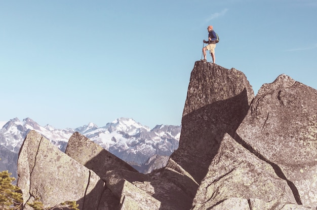 Uomo sulla scogliera di montagne. Scena dell'escursionismo.