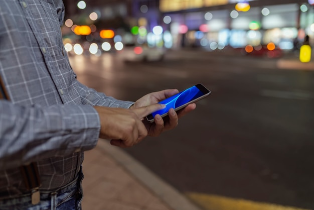 Uomo sulla strada con il telefono in mano