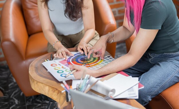 Uomo transgender LGBTQ Bello specialista autentico con i capelli rosa e trans non binario che lavora insieme Lavorare Design in un posto di lavoro creativo colleghi di lavoro di squadra Parità di genere