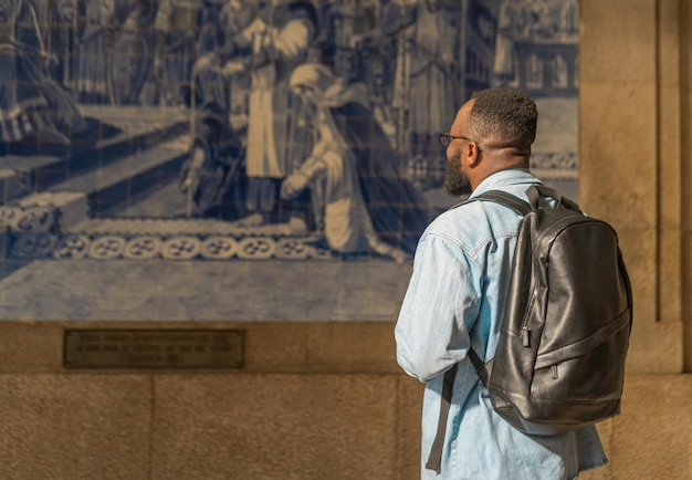 Uomo turistico afroamericano contro azulejo