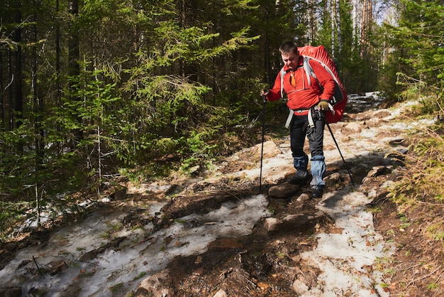 Uomo turistico che cammina sul fianco della montagna