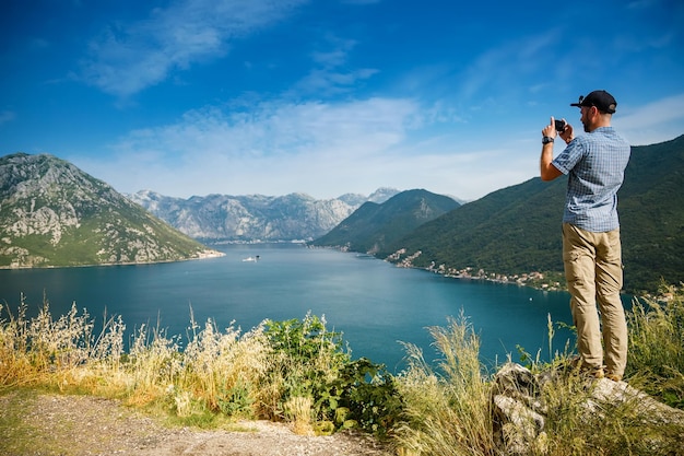 Uomo turistico che scatta una foto della baia di Kotor Montenegro