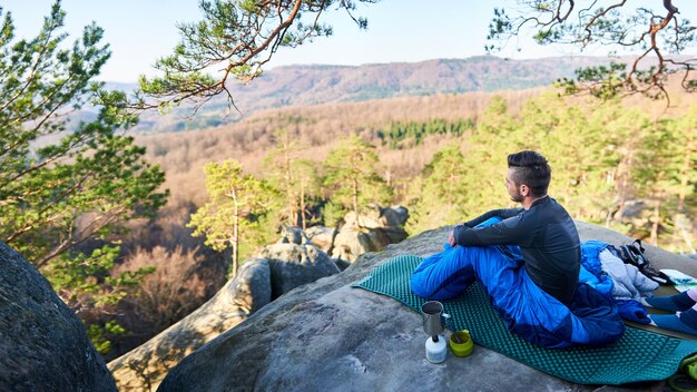 Uomo turistico in sacchi a pelo su grandi rocce