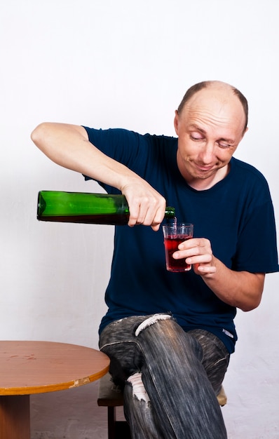 Uomo ubriaco che versa vino in un bicchiere