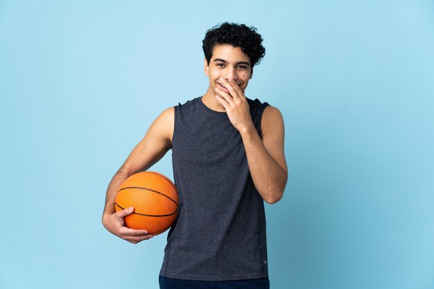 Uomo venezuelano del giocatore di pallacanestro sopra la bocca della copertura felice e sorridente isolata con la mano