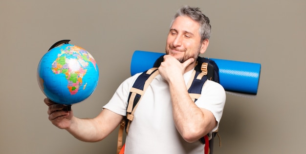 Uomo viaggiatore di mezza età con una mappa del globo del mondo