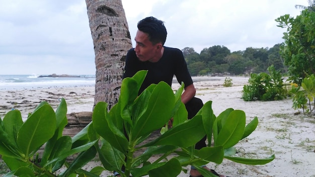 Uomo vicino alle piante sulla spiaggia