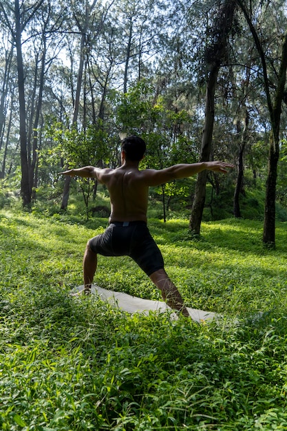 Uomo visto da vicino senza maglietta che fa allungamenti sul tappetino yoga esercizio america latina