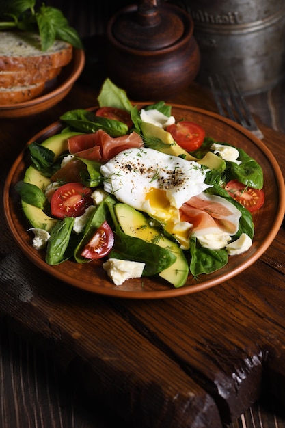 Uova alla Benedict in camicia con Prosciutto di Parma fettine di avocado pomodoro e tenerissime foglie di spinaci