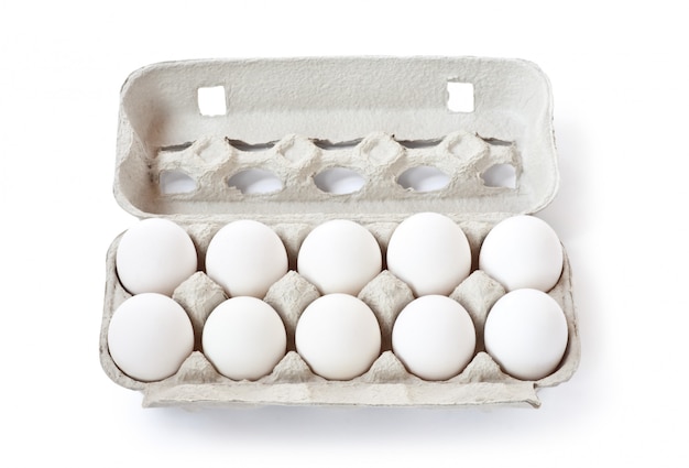 Uova bianche in contenitore di cartone isolato su bianco