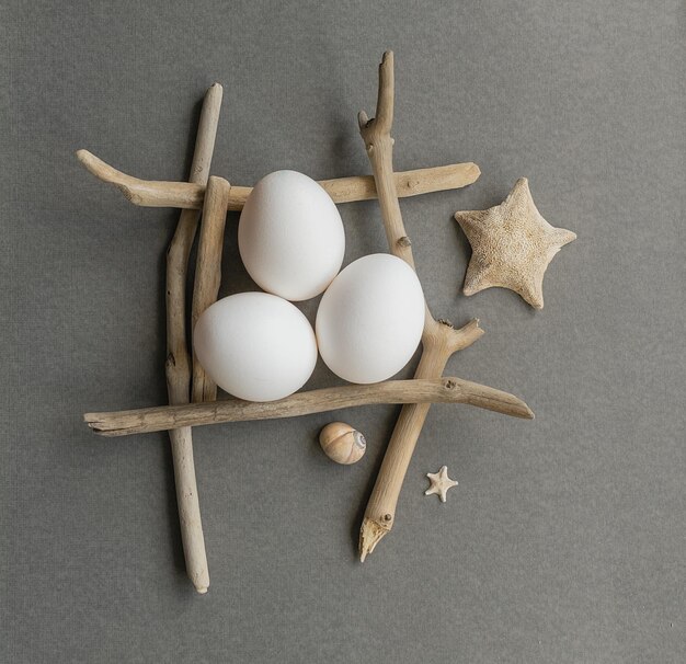 Uova bianche in una composizione pasquale con stelle marine e bastoncini di mare