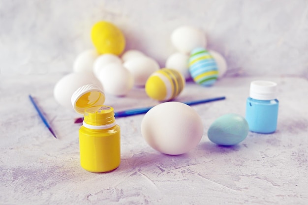 Uova bianche vernici e spazzole gialle e blu sul concetto di tavola simbolo Ucraina Pasqua