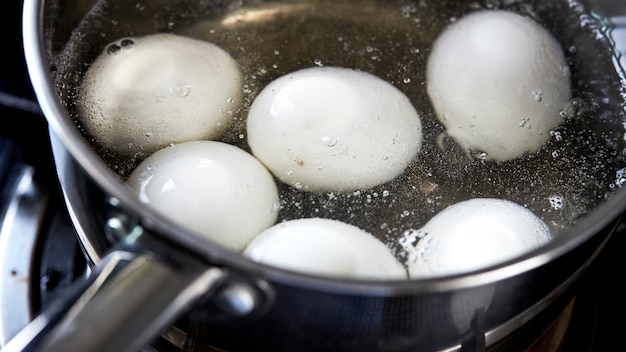 uova che bollono in padella di acqua