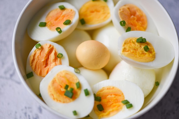 Uova colazione, uova fresche menu cibo uova sode in una ciotola decorata con foglie cipolle verdi fresche tritate, tagliate a metà tuorli d'uovo per cucinare mangiare sano