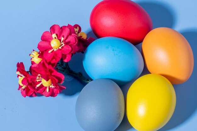 Uova colorate che simboleggiano la Pasqua su uno sfondo colorato e fiori