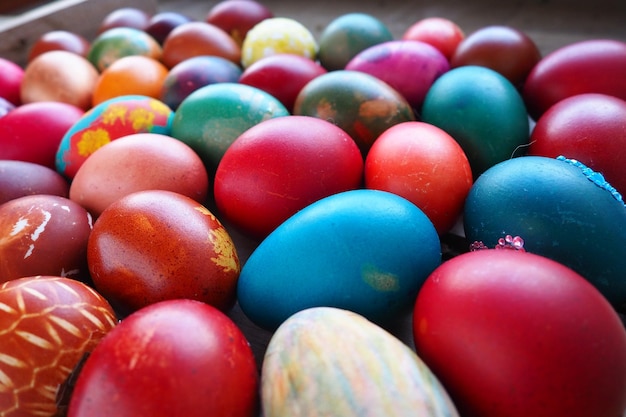 Uova colorate di Pasqua da vicino Molte uova colorate per le vacanze sono impilate l'una vicino all'altra Uova di gallina bollite con motivo floreale e fantasia Sfondo luminoso di Pasqua