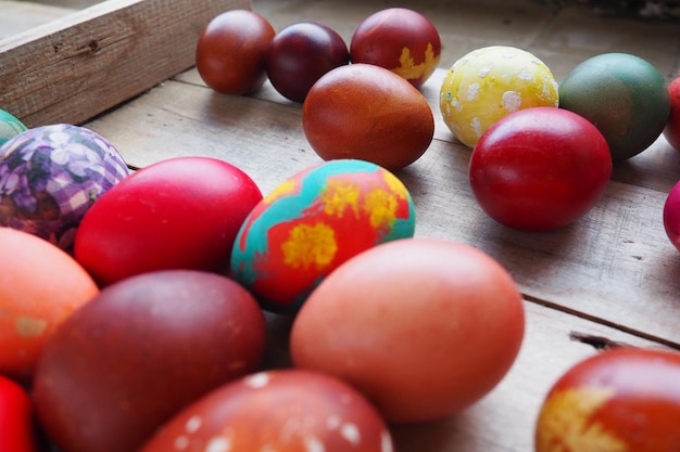 Uova colorate di Pasqua da vicino su sfondo di legno Molte uova colorate per le vacanze sono impilate l'una vicino all'altra Uova di gallina bollite con motivo floreale e fantasia Sfondo luminoso di Pasqua