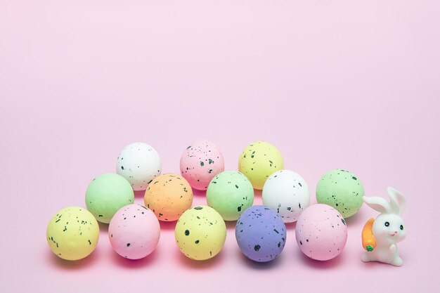 Uova colorate di Pasqua e coniglietto di Pasqua su sfondo rosa Pasqua