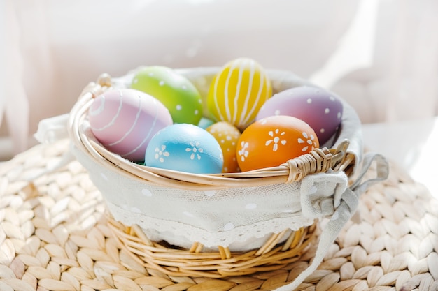 Uova colorate di Pasqua in busket bianco sulla tavola di legno. Tavola di Pasqua felice.